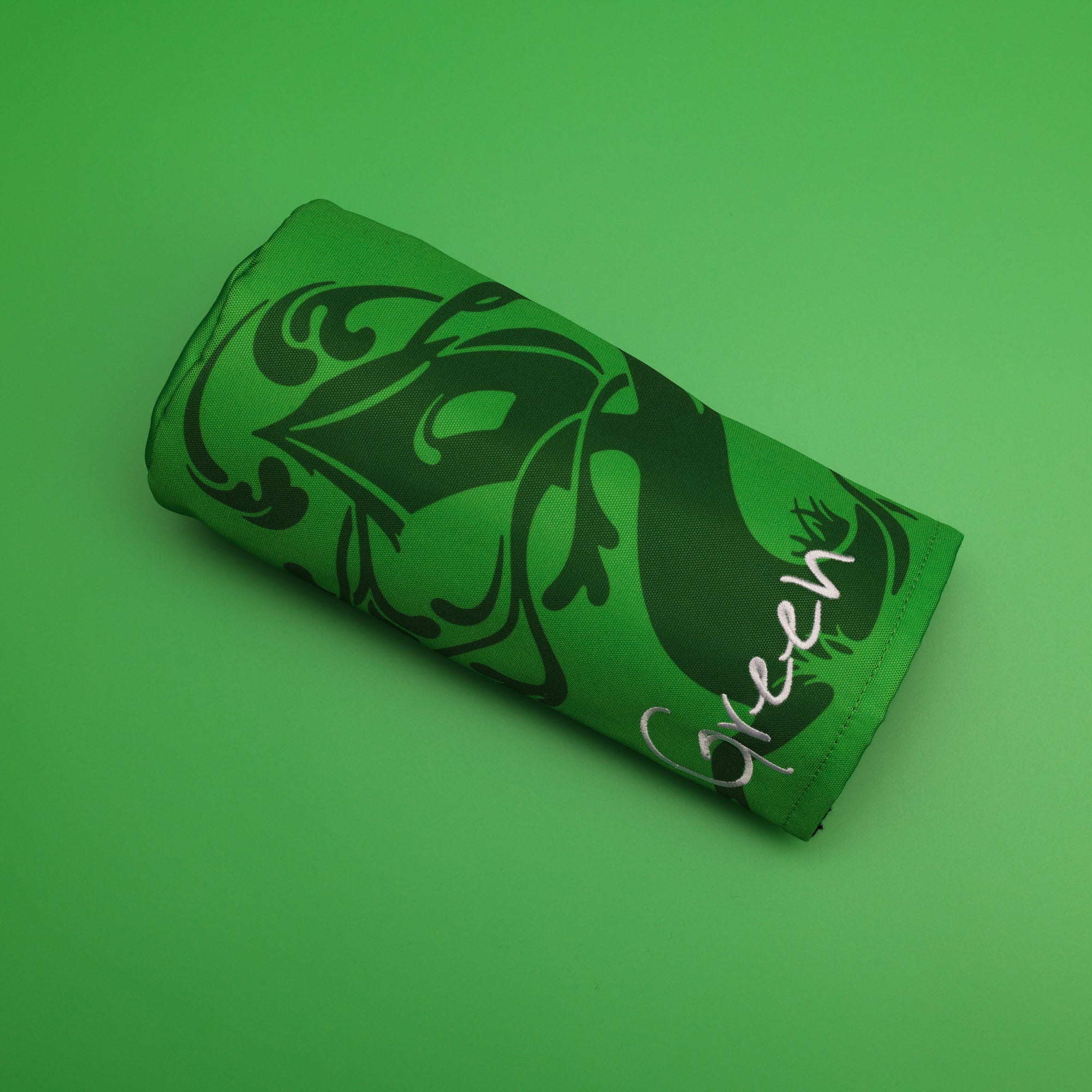 custom green barrel style golf headcover sitting on a green background made for tree house brewing by cayce golf