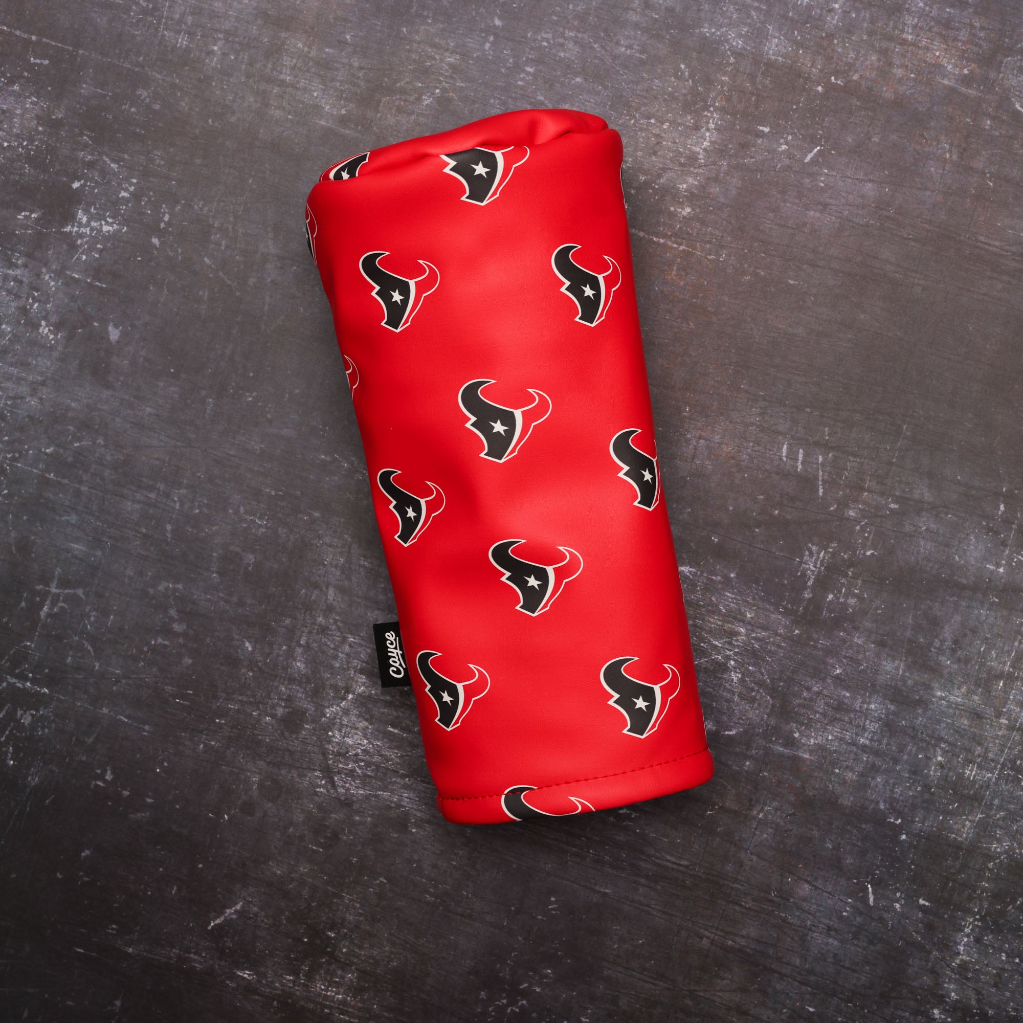 custom golf headcovers for the houston texans made by cayce golf sitting on a dirty steel background