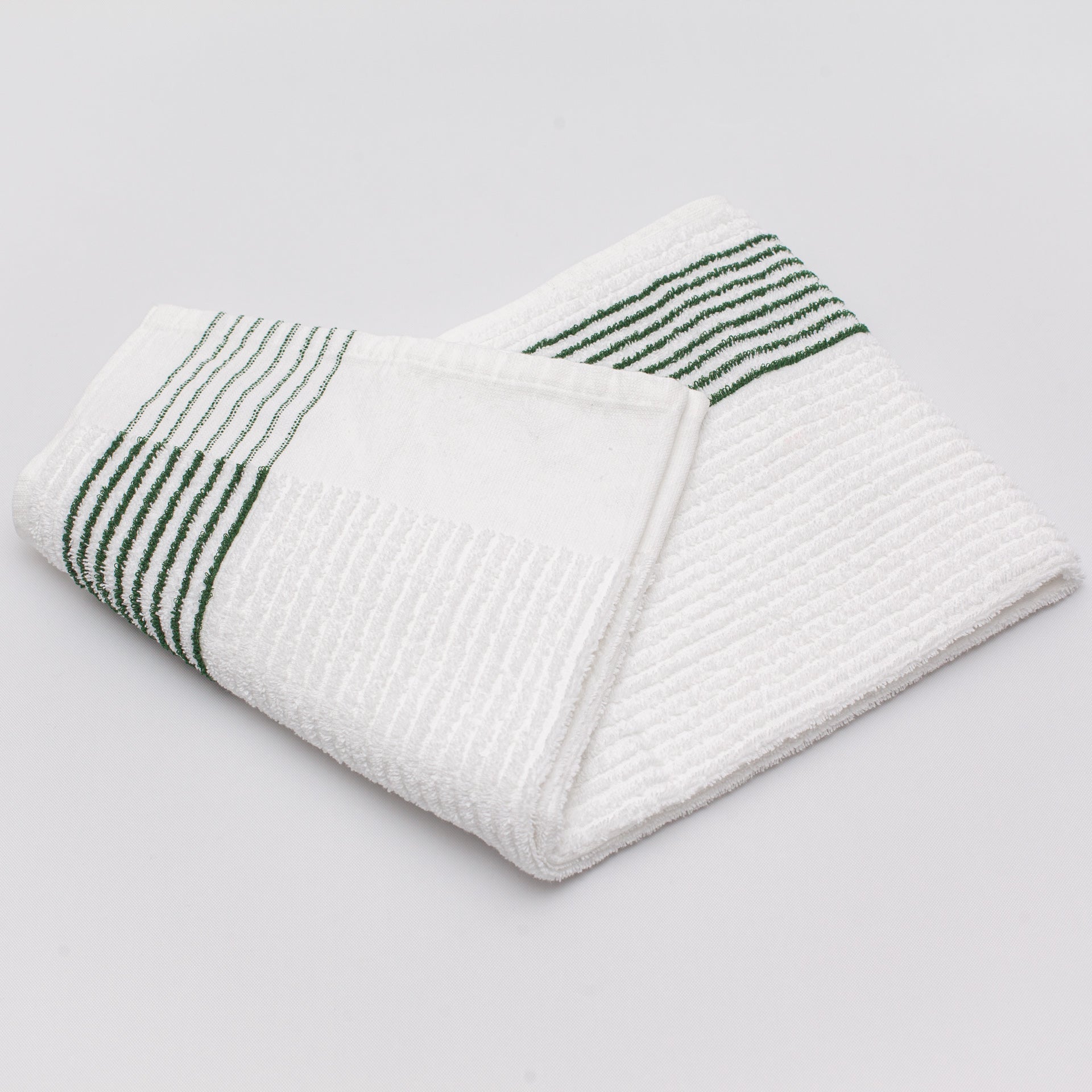 caddy towel with green stripes laying folded on a white background