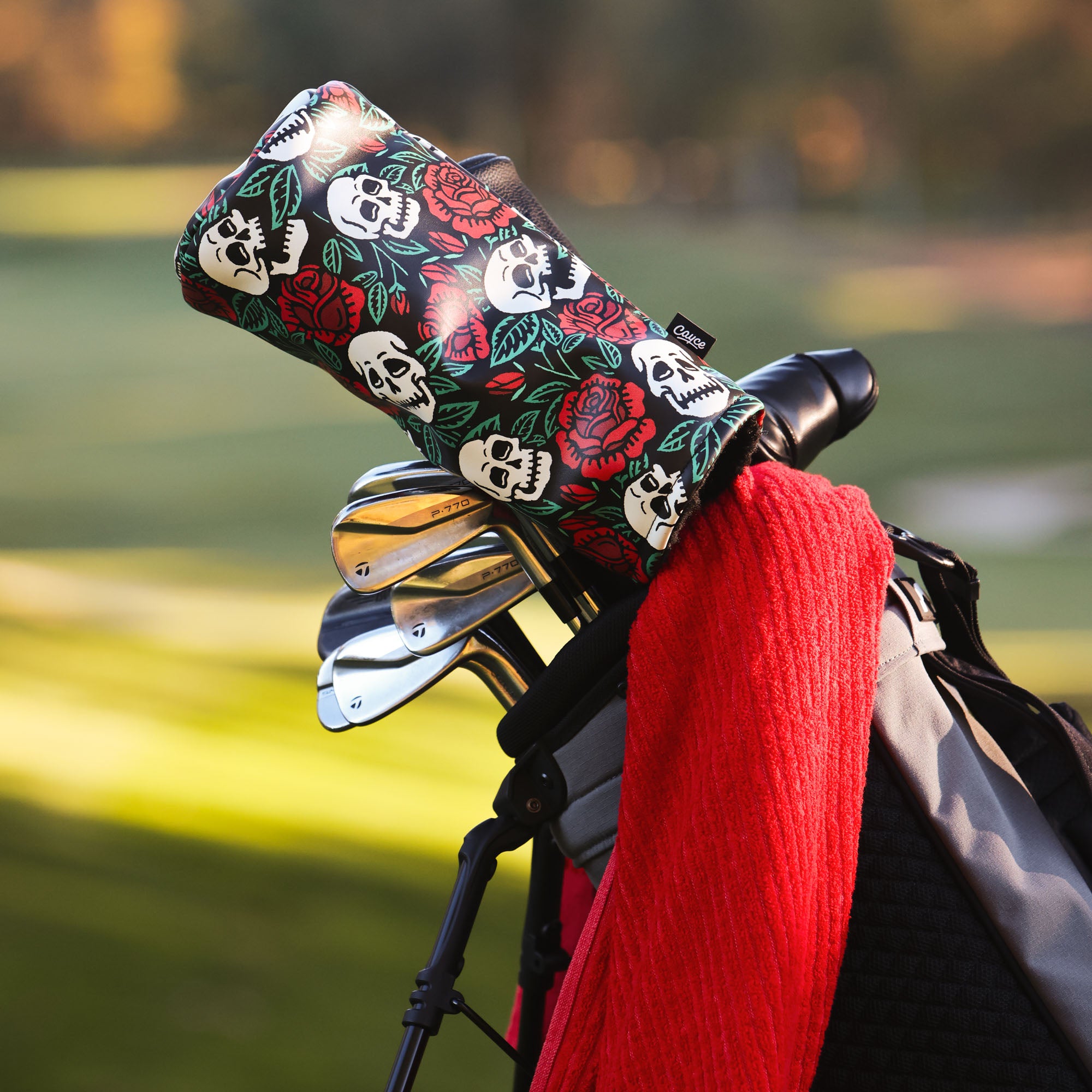 golf bag on a course with a rose and skull black driver headcover from cayce golf