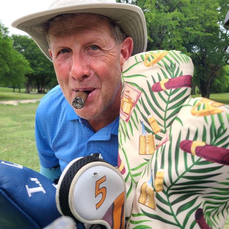 golfer smoking a cigar with his cigar golf head covers from cayce golf