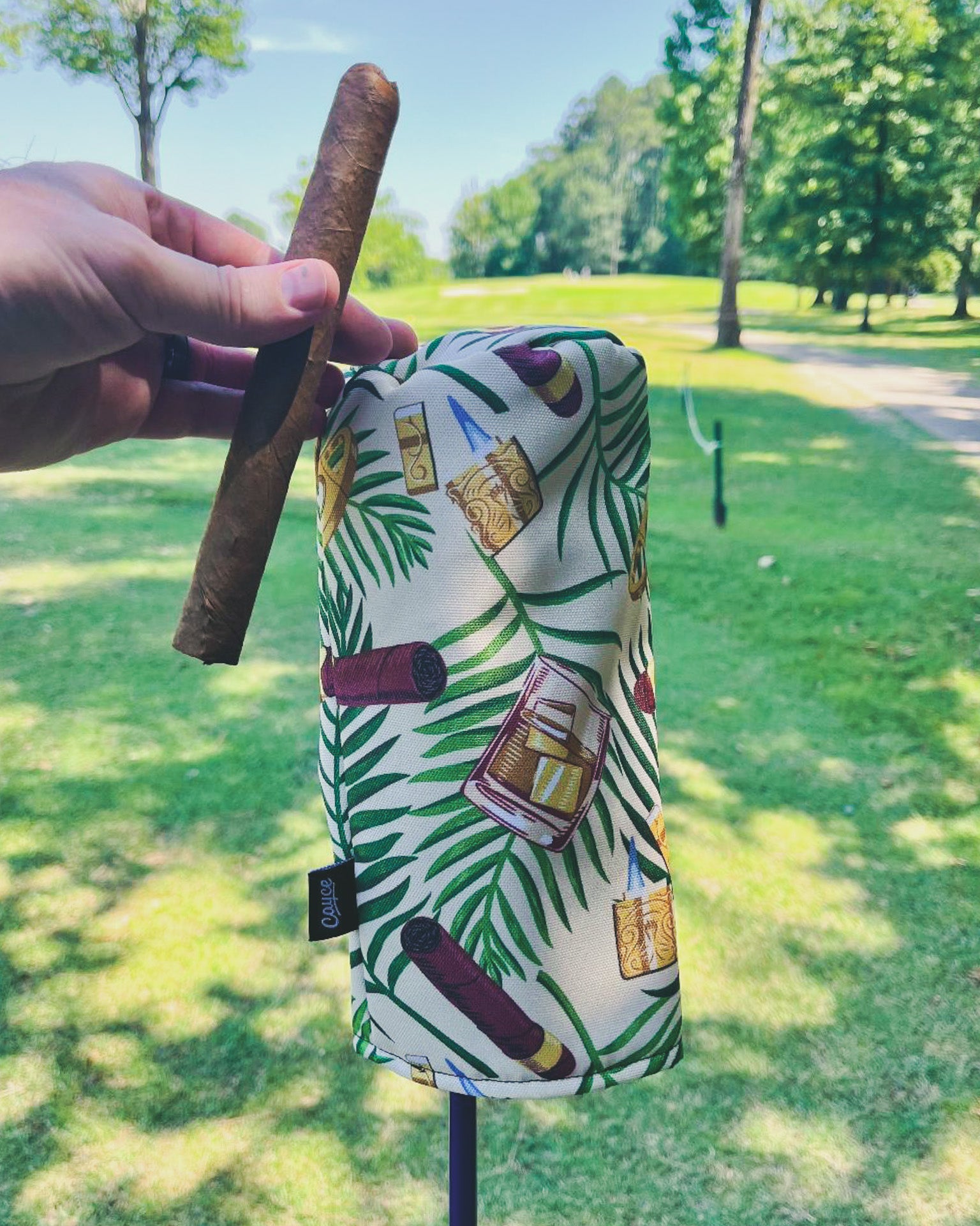 golfer holding a cigar and cigar themed driver head cover 