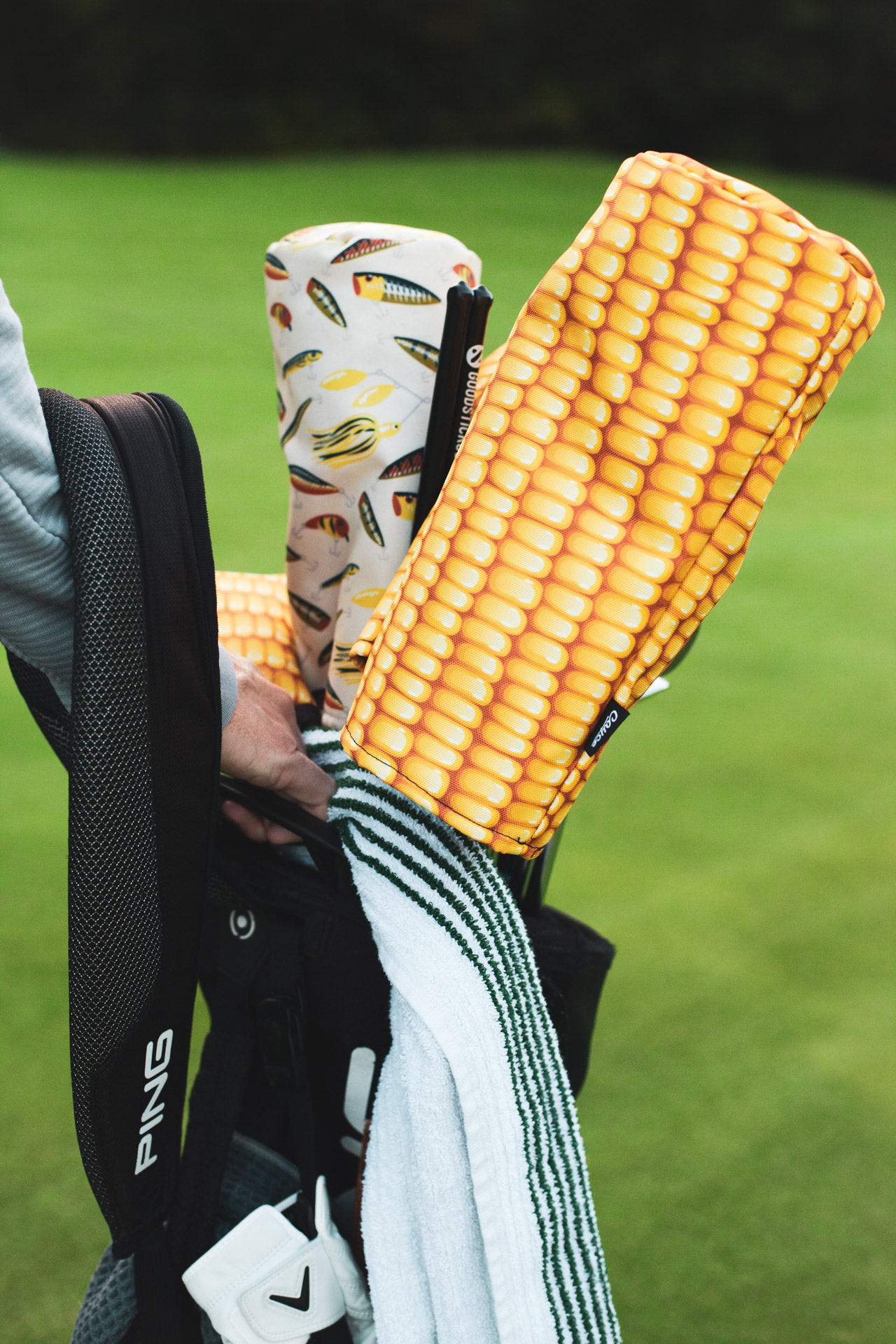 golfer holding up his golf bag with corn driver headcover